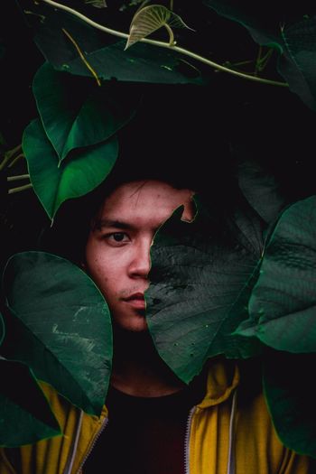 Close-up portrait of young man amidst leaves