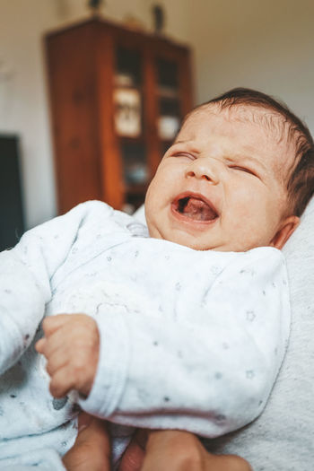 Close-up of crying baby at home
