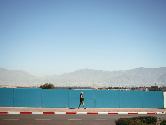 Side view of woman walking on sidewalk