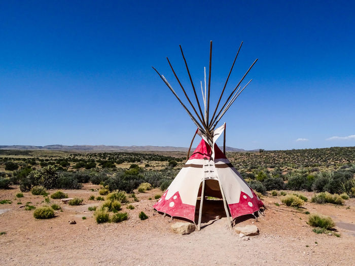 Traditional tent on field against clear blue sky