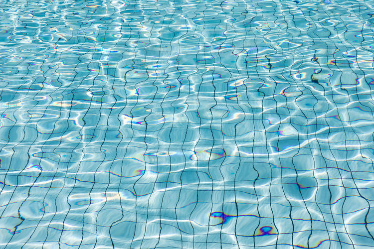Sun reflection in clear clean and bright blue water of swimming pool
