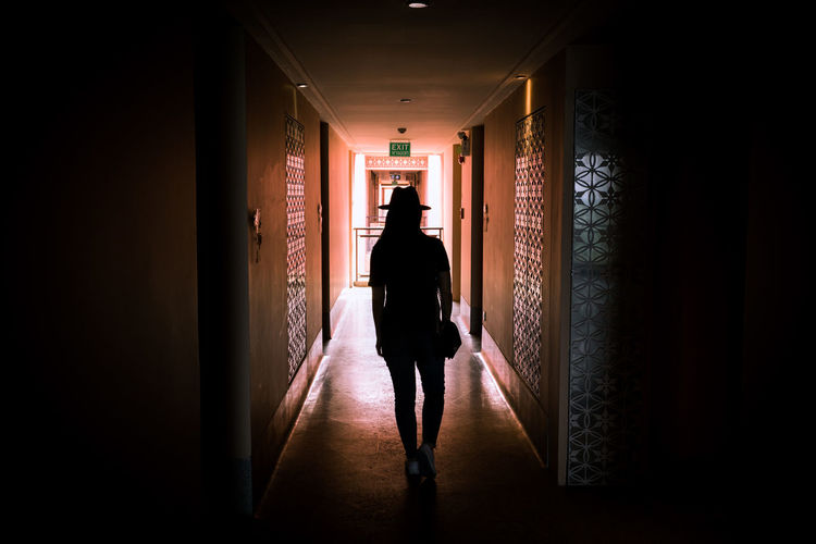 Silhouette woman walking in building corridor