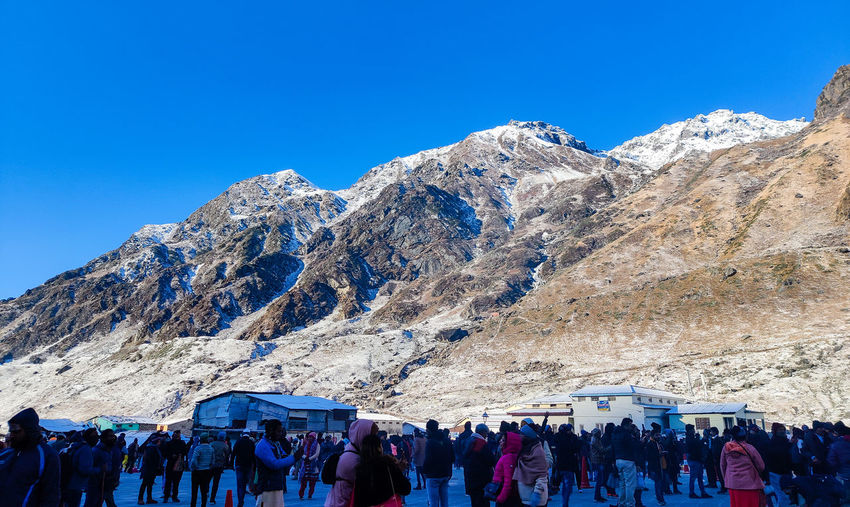 People on mountain against clear blue sky