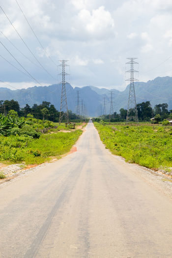 Road amidst green landscape against sky