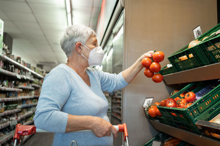 Caucasian elderly woman with white hair shopping in supermarket