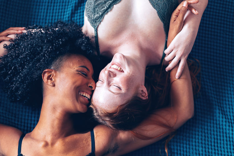 Two young happy women lying down laughing together
