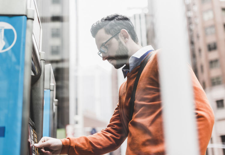 Usa, new york city, businessman using atm