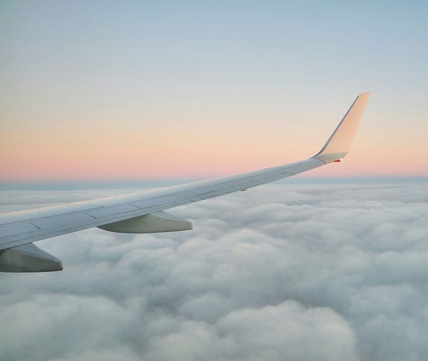 Cropped image of airplane flying over clouds