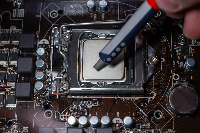 Directly above shot of hand holding injection over computer chip