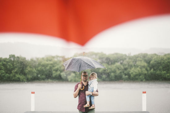 Portrait of father and son standing in rain