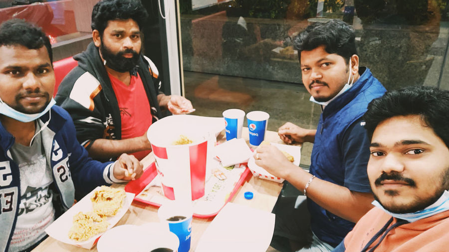 Portrait of friends sitting on table at restaurant