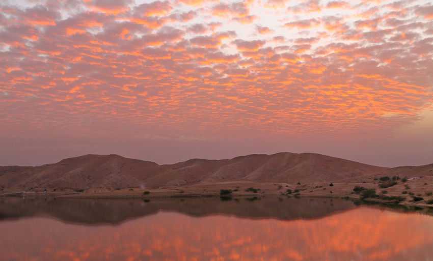 Scenic view of lake against orange sky