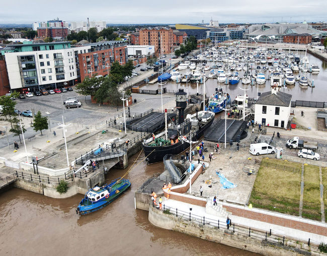 High angle view of boats moored on sea by buildings in city