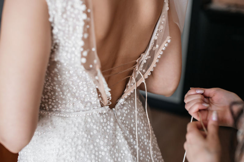midsection of bride holding flower bouquet