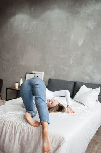 Woman lying on bed at home
