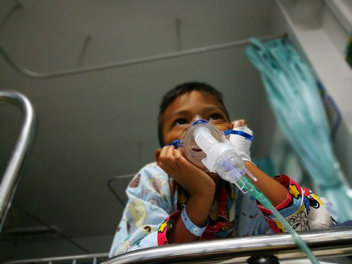 Low angle view of boy with oxygen mask in hospital