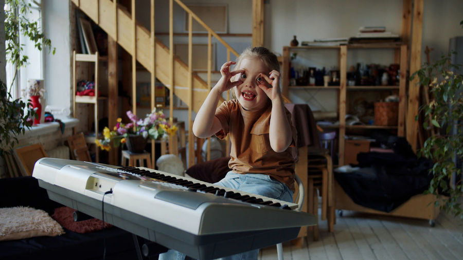 Portrait of girl playing piano at home