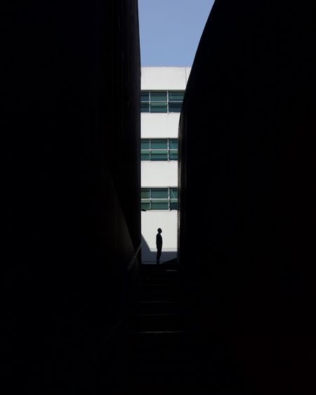 Silhouette man amidst buildings