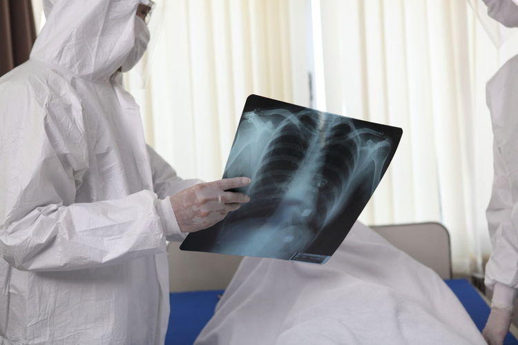 Midsection of doctors discussing medical x-ray in hospital