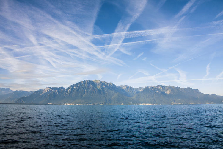 Scenic view of lake and mountains against blue sky