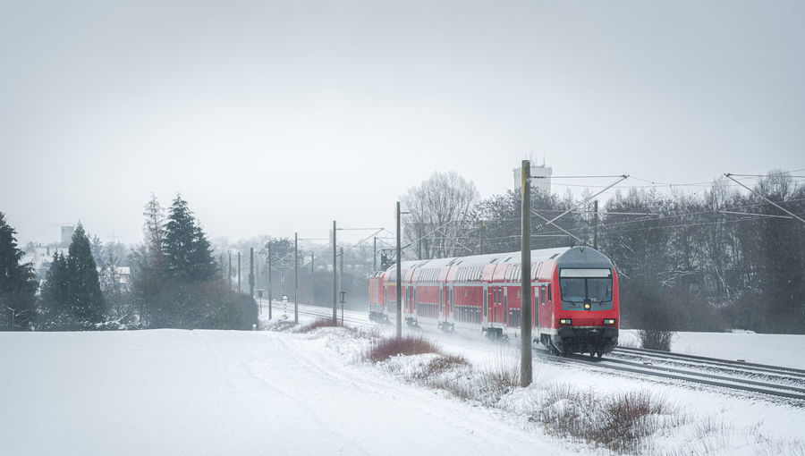 Train on railroad track against sky during winter