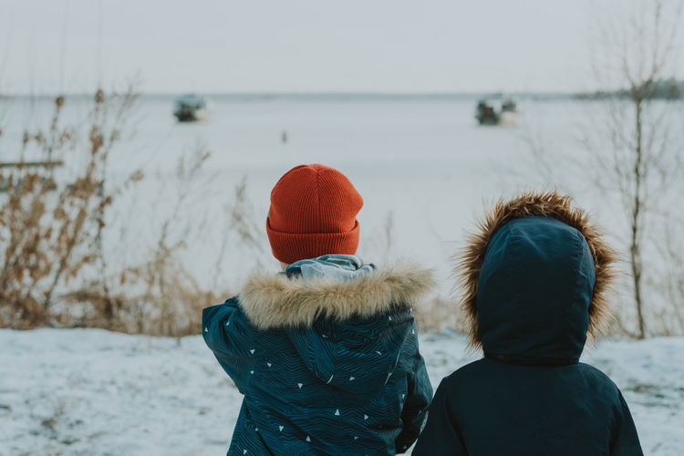 Children look at the winter landscape. children watch the winter sea. walk in winter by the sea.
