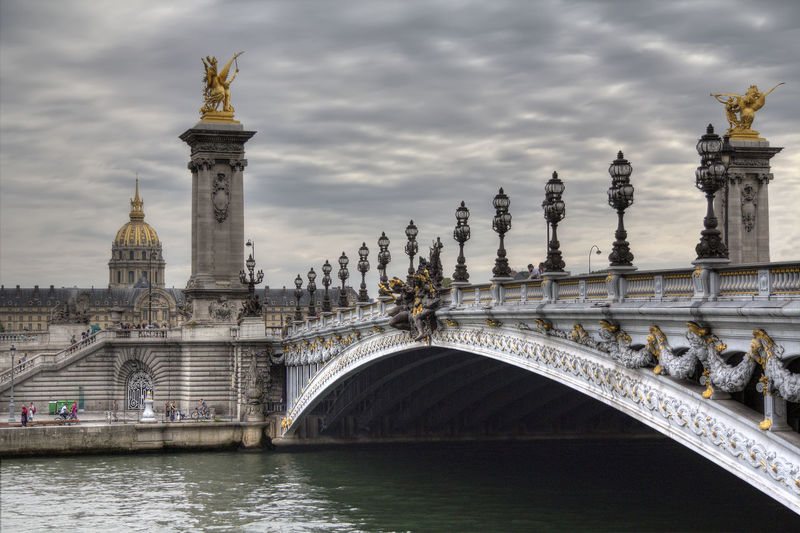 Pont alexandre iii over seine river against cloudy sky 