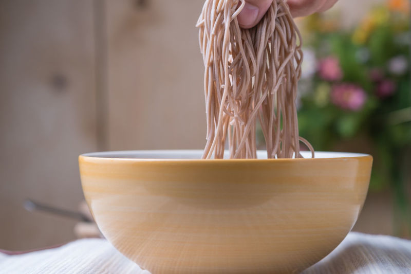 Close-up of  hand holding noodles
