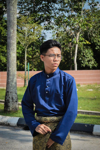 Portrait of young man against trees