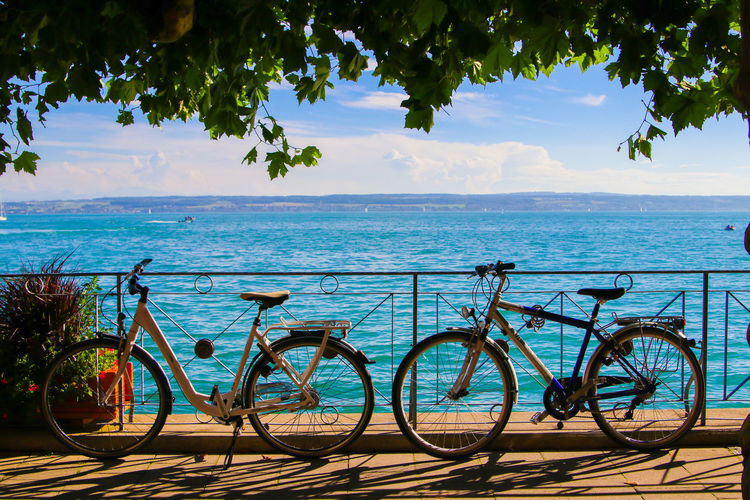 Bicycle by sea against sky