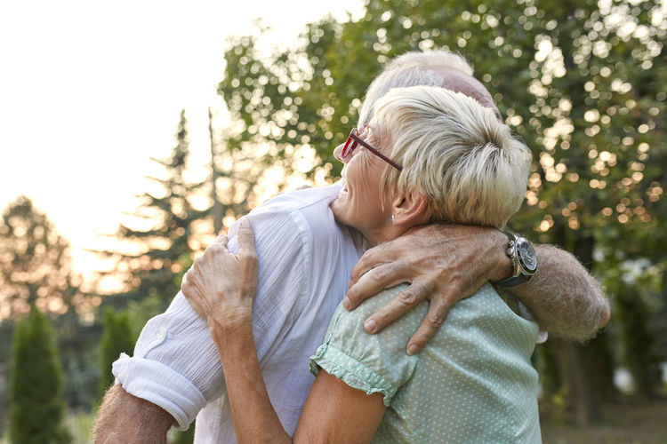 Happy senior couple hugging outdoors