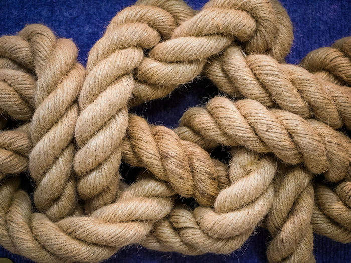 Close-up of rope tied up on blue background