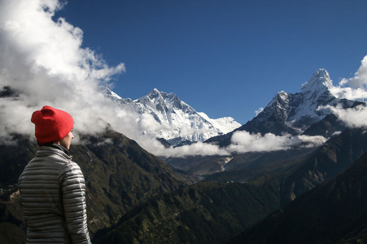 Woman looking at snowcapped mountains against sky