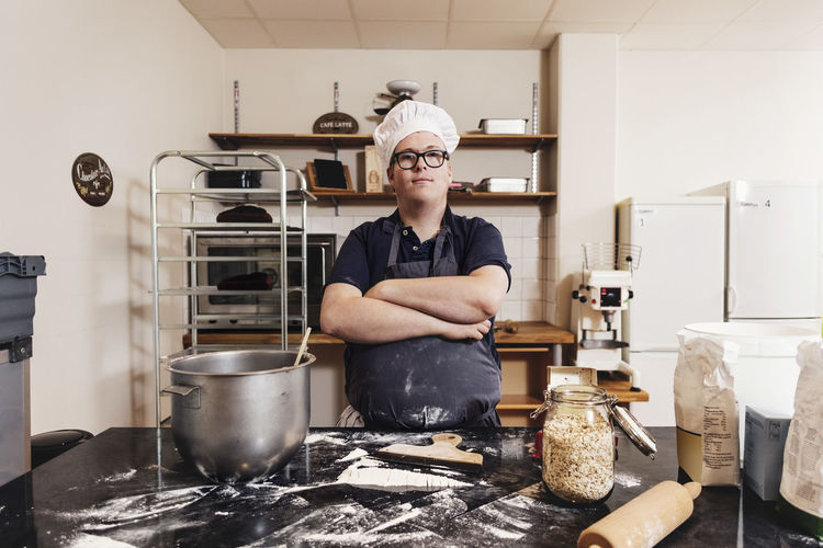 Portrait of smiling man preparing food in kitchen