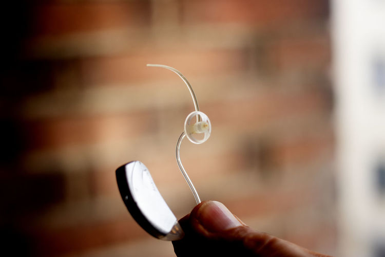 Close-up of hand holding hearing aid