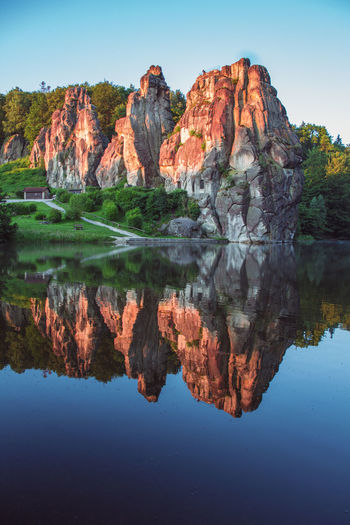 Reflection of rock formation in lake against sky