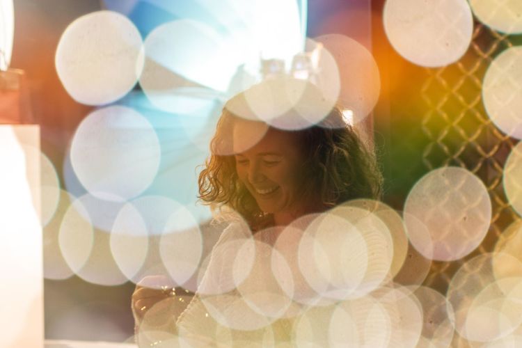 Double exposure of smiling beautiful woman with lens flare