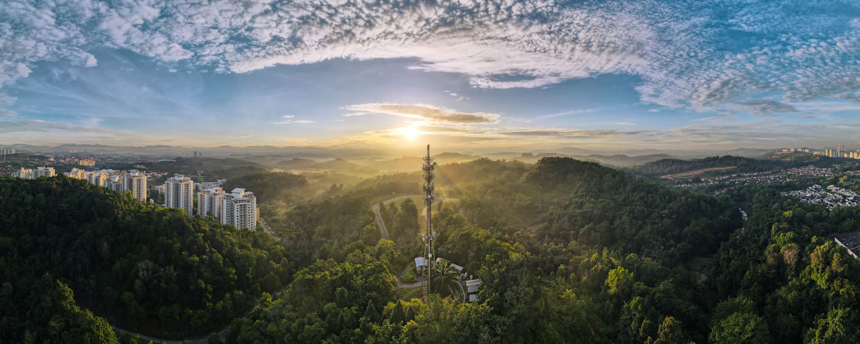 Aerial view of 5g communication tower during beautiful sunrise with clouds