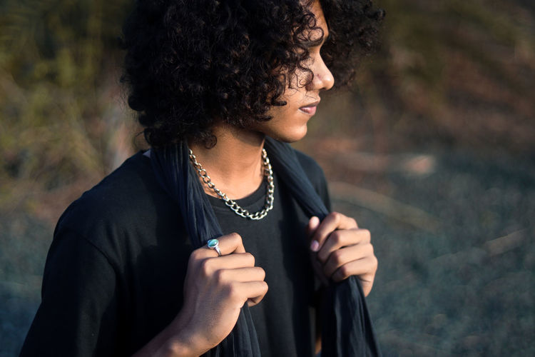 A guy with curly hair in black dress