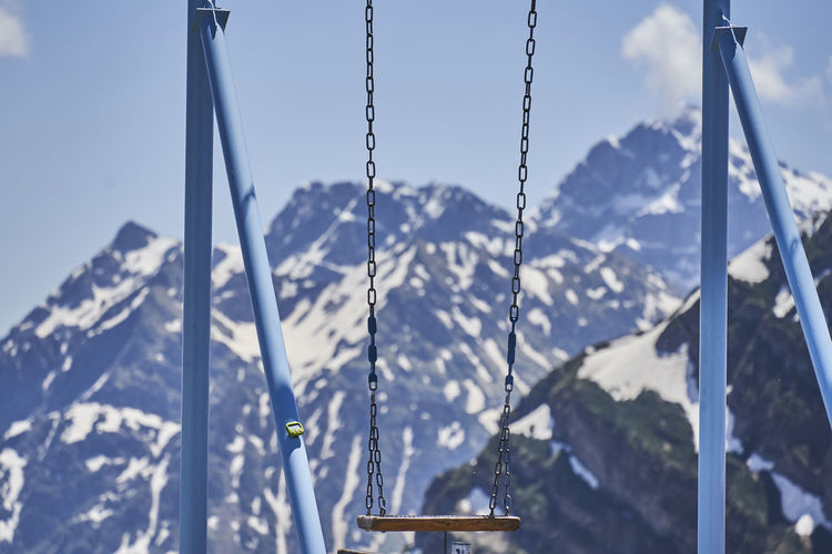 Close-up of swing against snow covered mountains