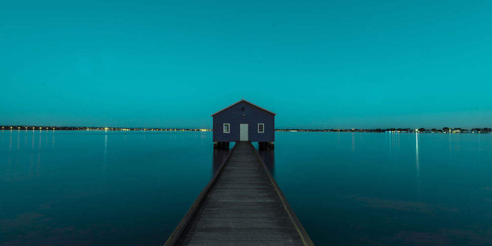 Pier over lake against blue sky