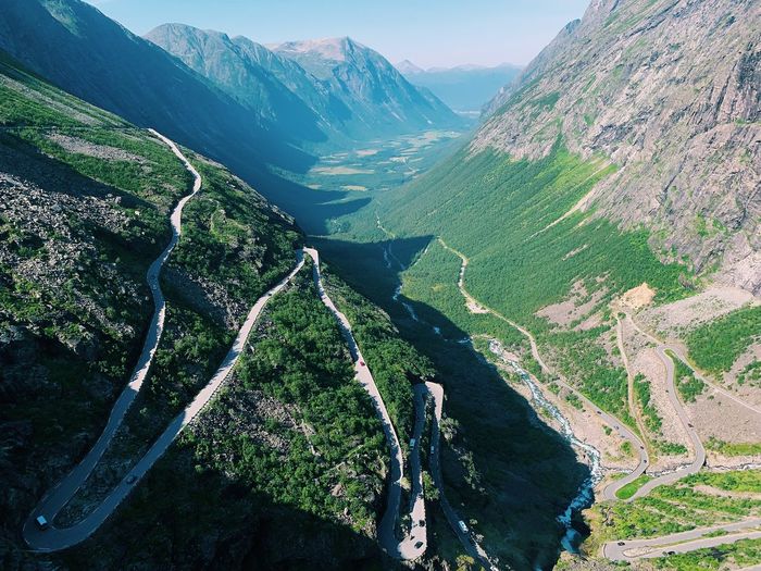Aerial view of a nordic valley with perspective and high mountains, climbing road 