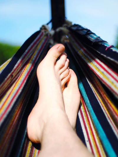 Low section of woman resting in hammock