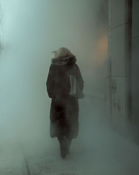 Rear view of woman walking in fog