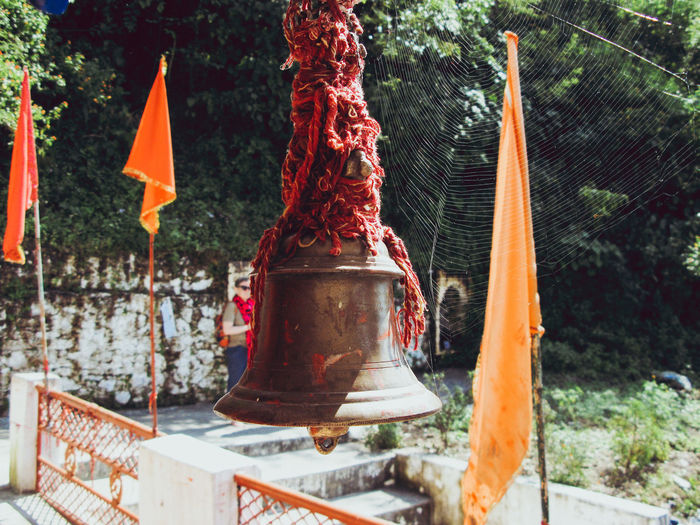 Close-up of red bell hanging on tree at temple
