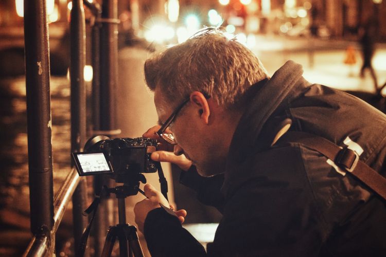 Man photographing through camera at night