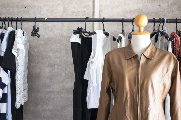 Clothes hanging on rack against wall in store
