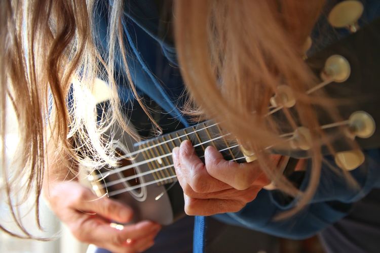 Midsection of woman playing guitar