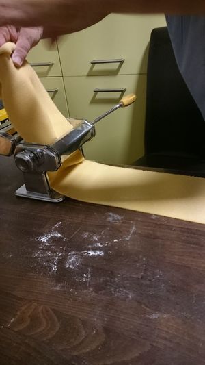 Midsection of person holding dough in paste maker on table