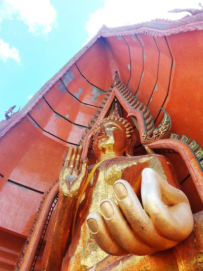 Close-up of buddha statue against sky